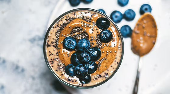 Chocolate almond butter smoothie with chia seeds, blueberries, and ARLO culinary argan oil for a rich, antioxidant-packed drink