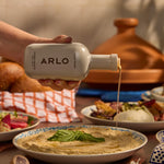 Drizzling ARLO Culinary Argan Oil over creamy hummus, showcasing premium Moroccan flavor in Mediterranean cuisine